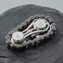 Sprocket Flywheel Chain Spinner. A mechanical chain spinner that feels incredible to fidget with. A pocket-sized machine for endlessly satisfying spins.